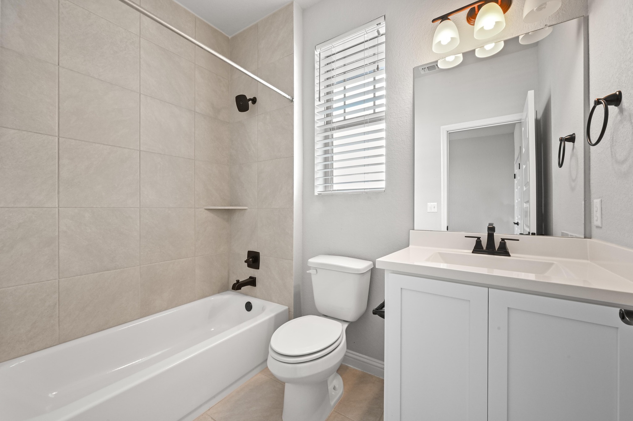 8003 Orizzonte Street Austin, TX 78744 - Photo 22 of 25 Bathroom featuring shower combination, vanity, and light tile patterned floors