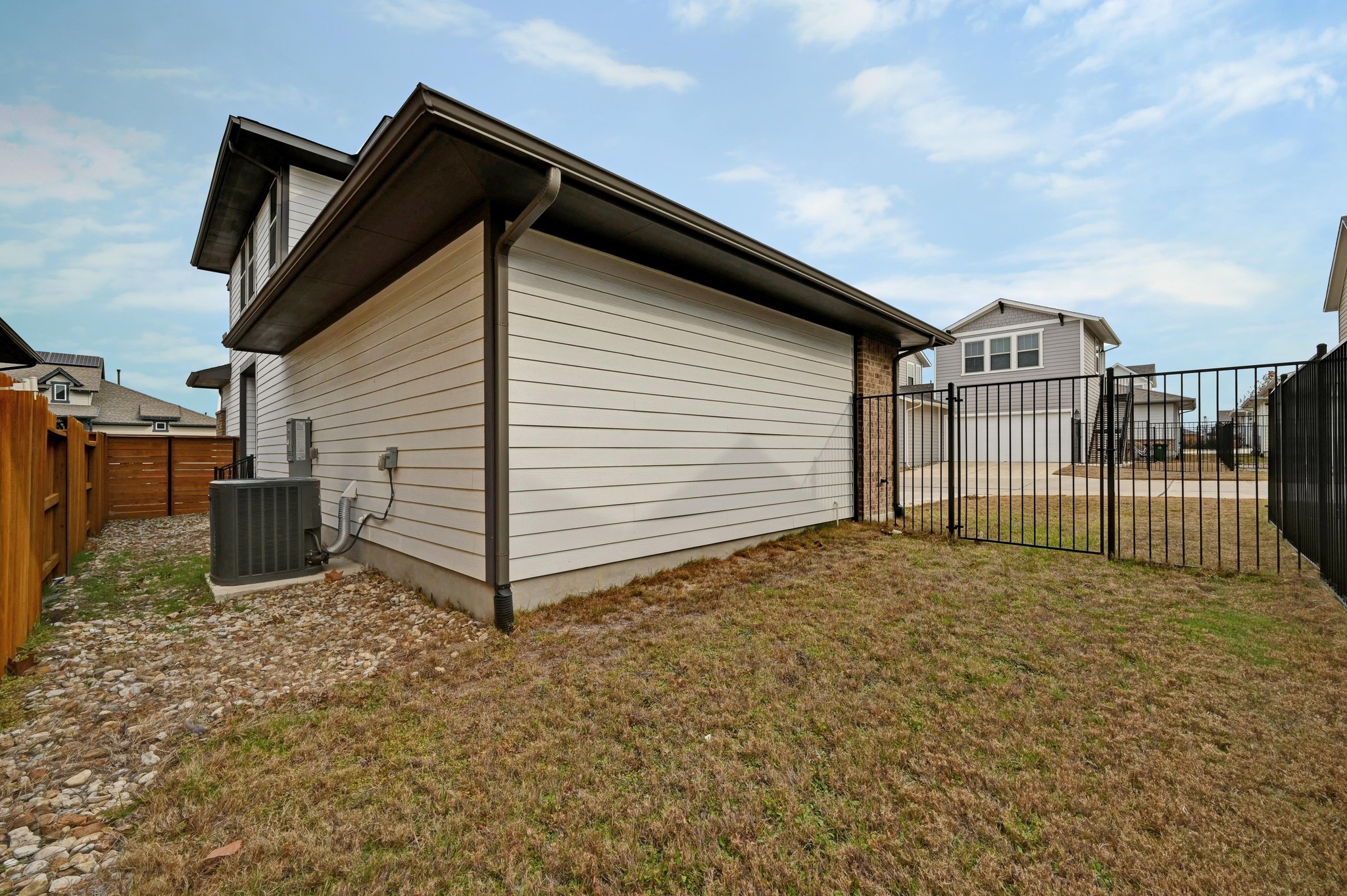 8003 Orizzonte Street Austin, TX 78744 - Photo 25 of 25 View of property exterior with a fenced backyard and a gate