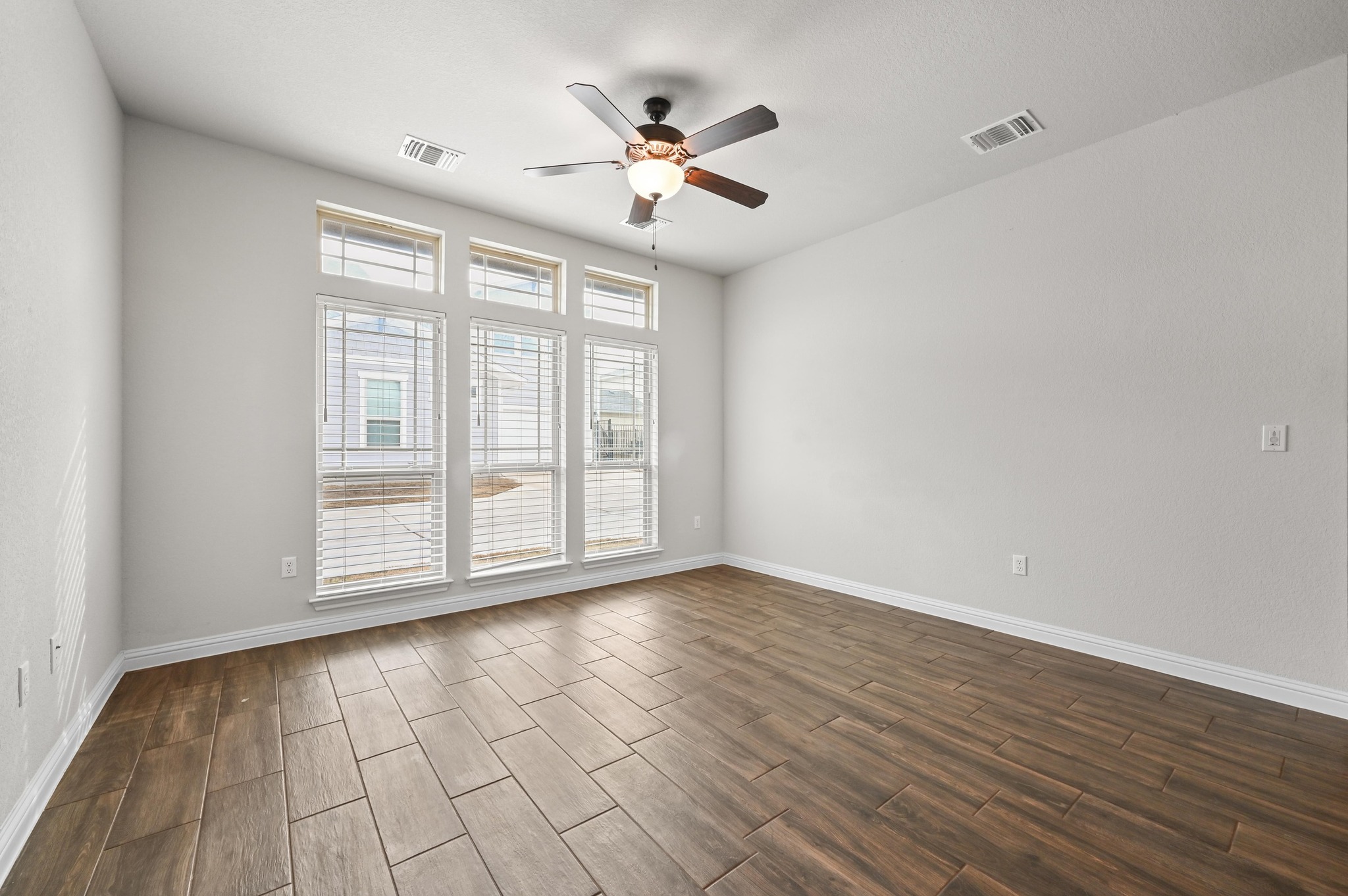8003 Orizzonte Street Austin, TX 78744 - Photo 6 of 25 Spare room featuring wood tiled floors and a ceiling fan