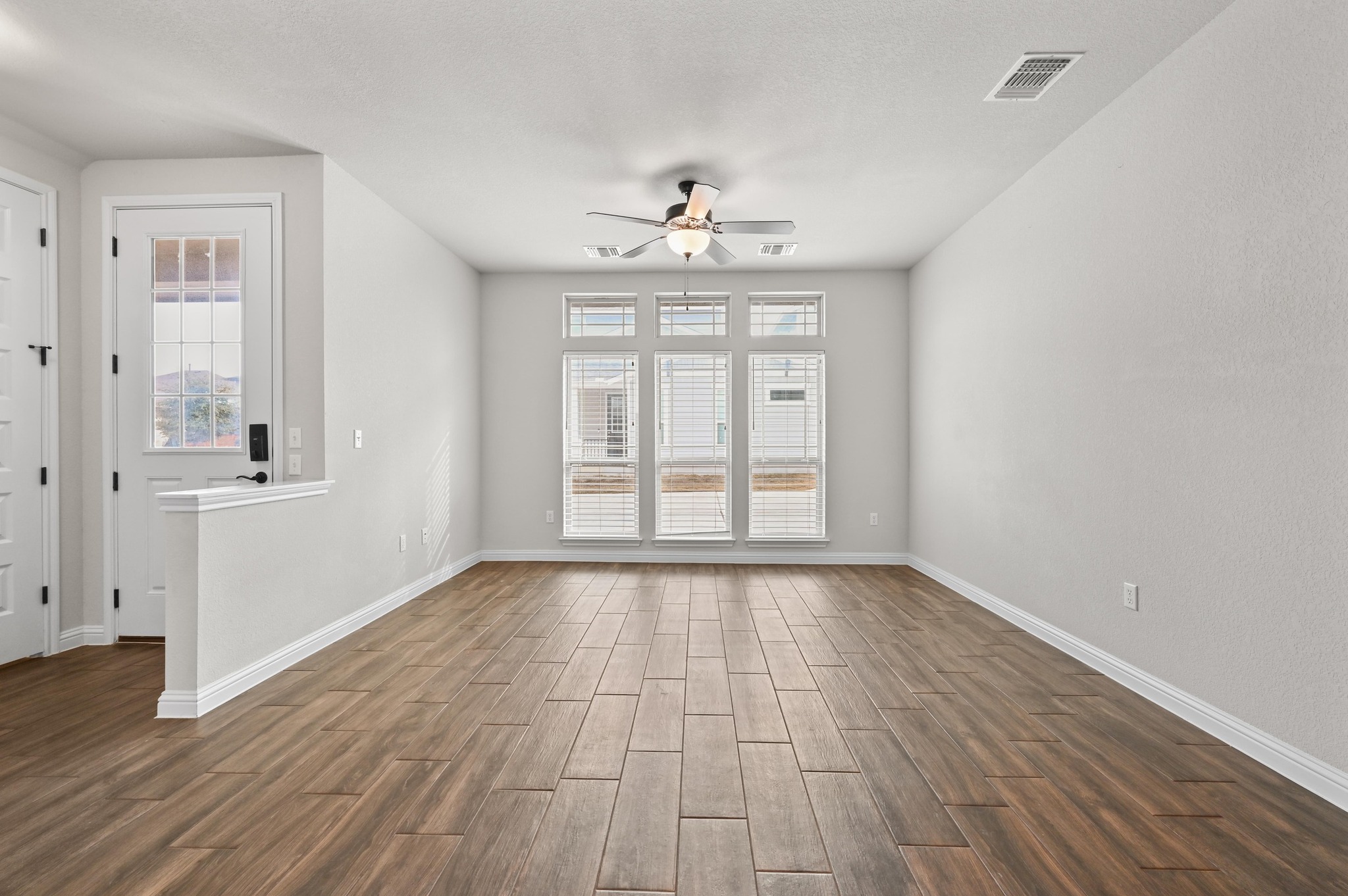 8003 Orizzonte Street Austin, TX 78744 - Photo 7 of 25 Spare room with wood tiled floors, healthy amount of natural light, and ceiling fan