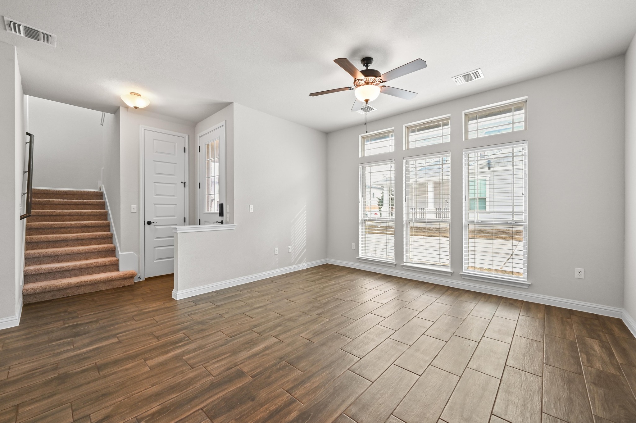 8003 Orizzonte Street Austin, TX 78744 - Photo 8 of 25 Unfurnished living room with wood tiled floors and a ceiling fan