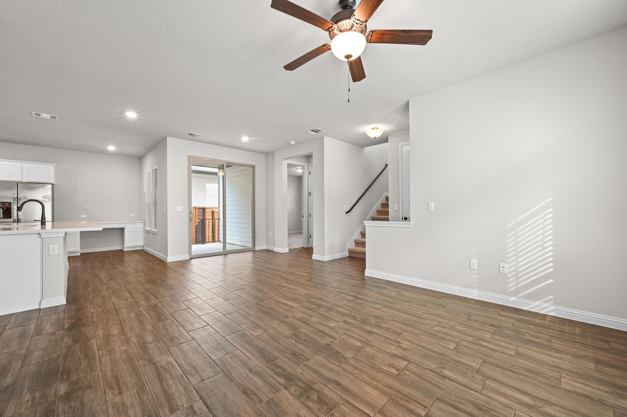 8003 Orizzonte Street Austin, TX 78744 - Photo 9 of 25 Unfurnished living room featuring a ceiling fan, dark wood finished floors, and recessed lighting