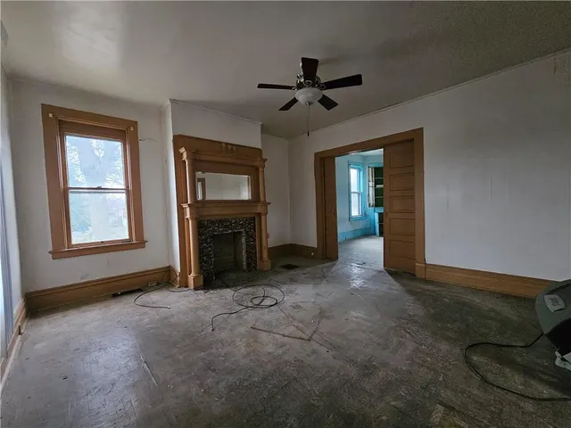 a view of an empty room with a fireplace and a window