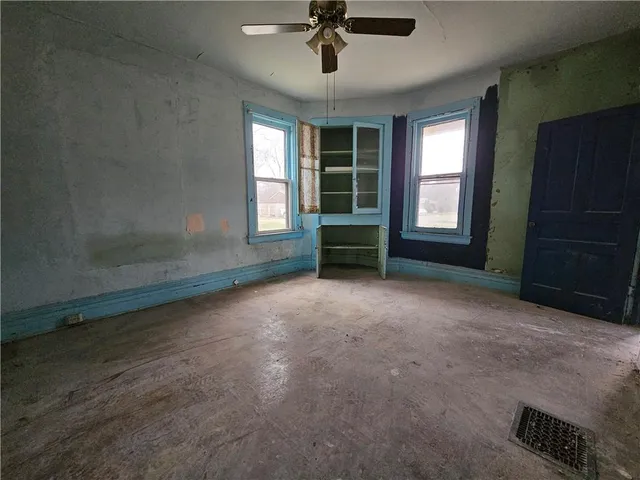 an empty room with windows and closet