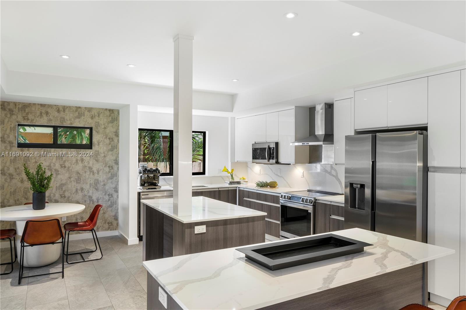 2429 Southwest 25th Terrace Miami, FL 33133 - Photo 18 of 35 a kitchen with a refrigerator a sink and chairs