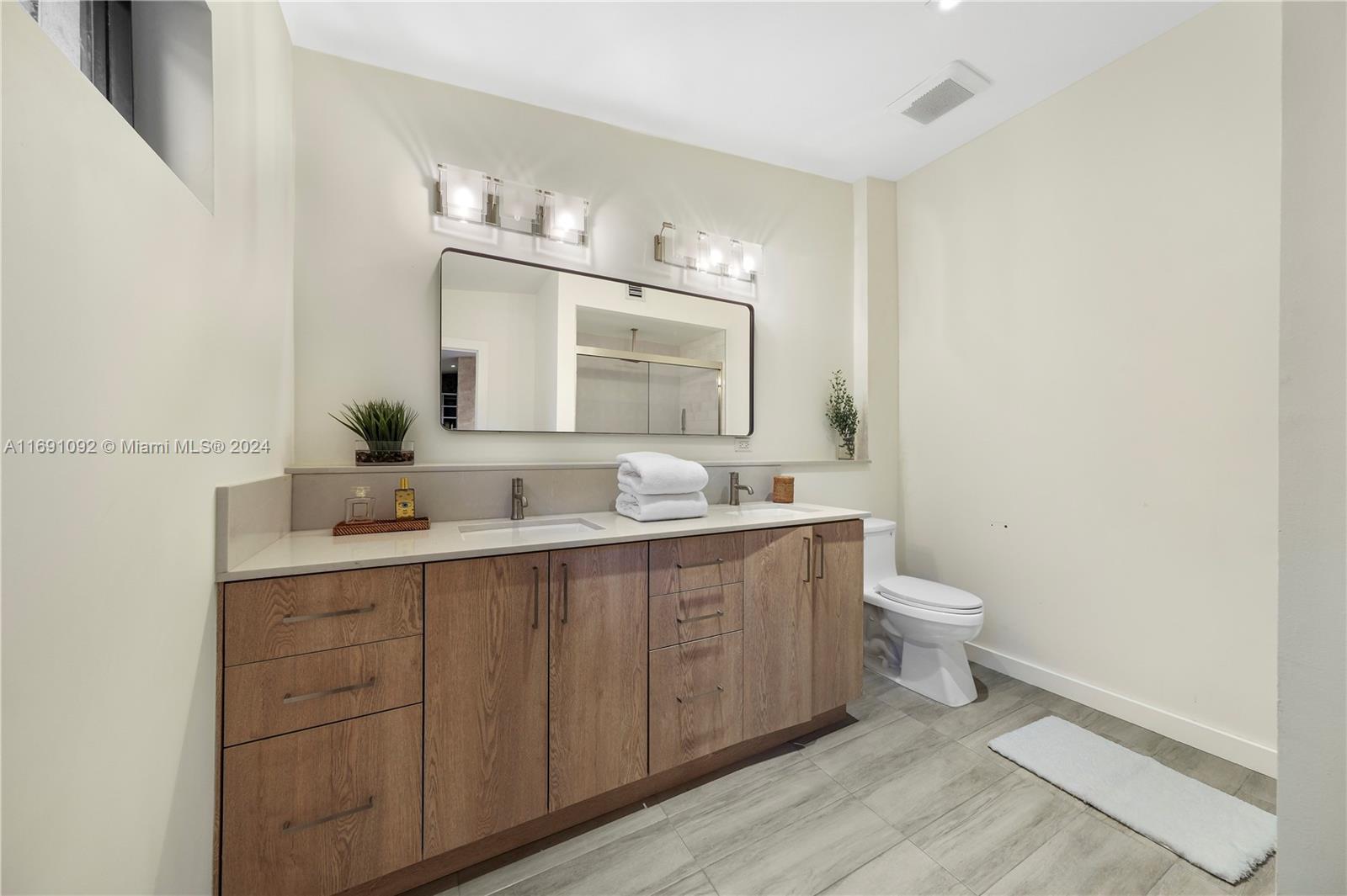 2429 Southwest 25th Terrace Miami, FL 33133 - Photo 25 of 35 a bathroom with a toilet sink and mirror