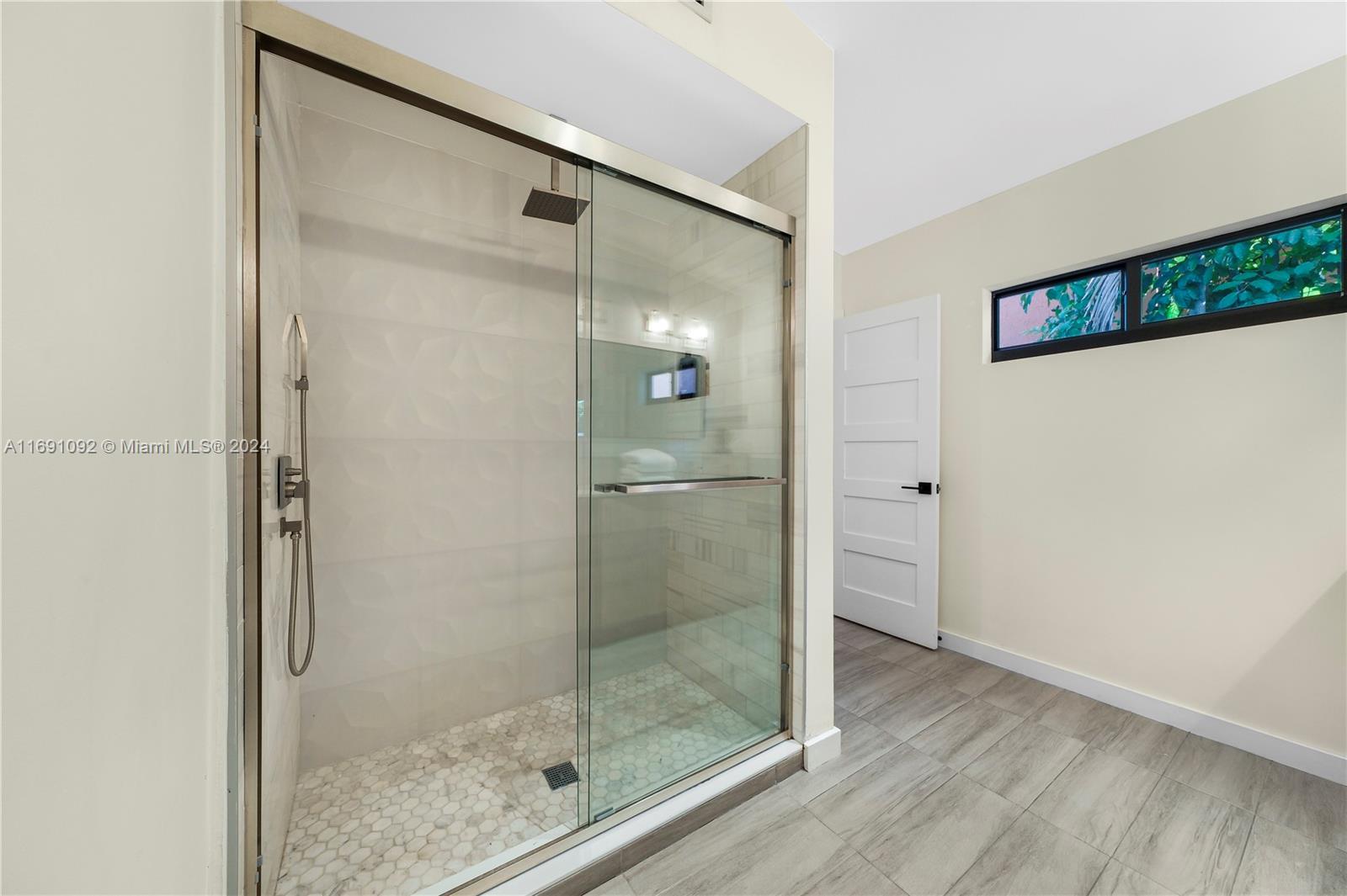 2429 Southwest 25th Terrace Miami, FL 33133 - Photo 27 of 35 a bathroom with a glass shower door