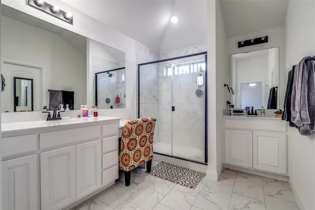a bathroom with a double vanity sink mirror and shower