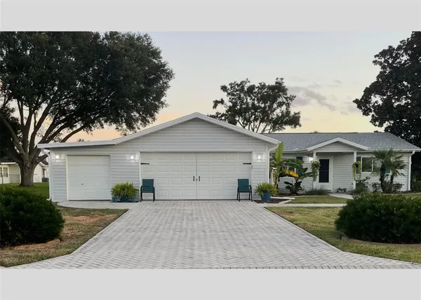 a front view of a house with a yard and potted plants