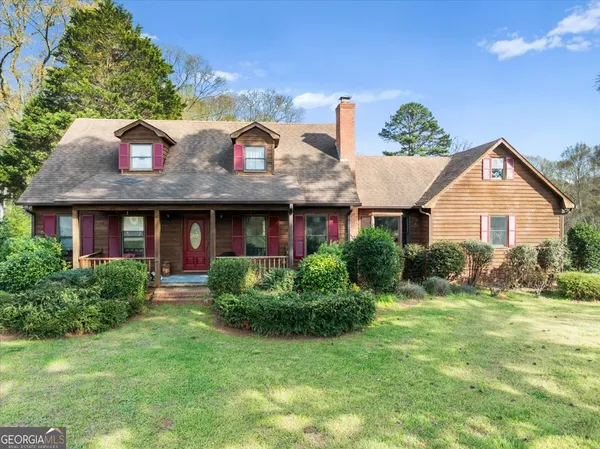 a view of a brick house with a yard potted plants and a table