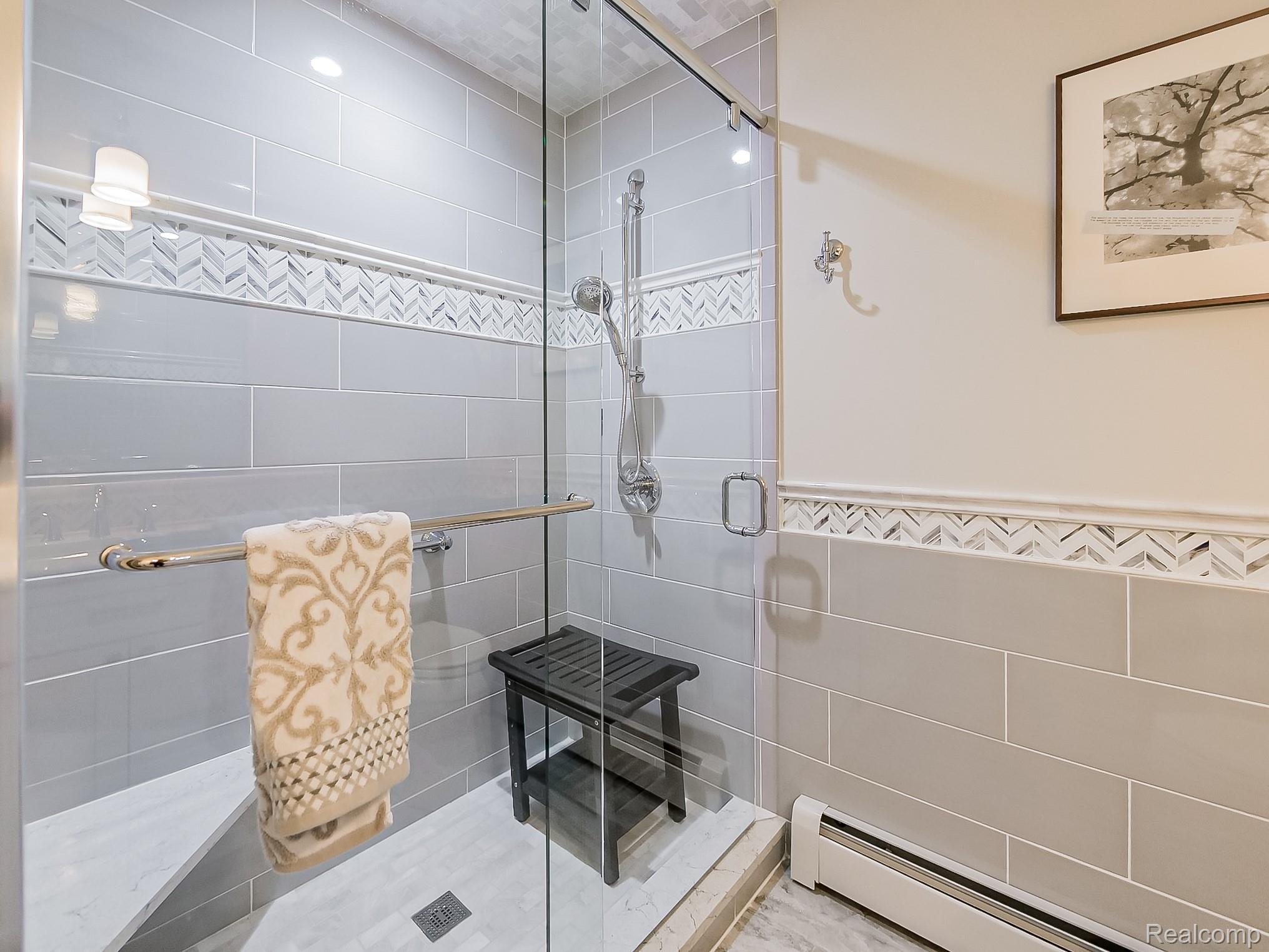 3720 East Clarkston Road Oakland, MI 48363 - Photo 17 of 60 Bathroom featuring baseboard heating, tile walls, and a stall shower