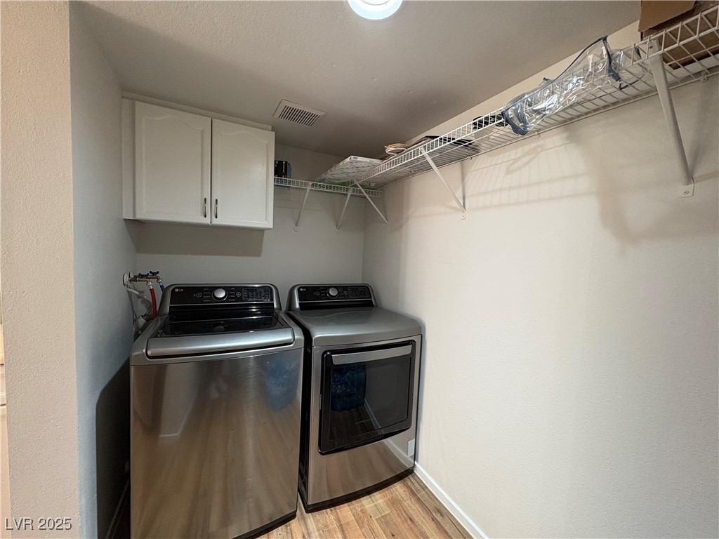 7931 Trea Avenue Las Vegas, NV 89147 - Photo 11 of 25 Washroom featuring light wood-style floors, separate washer and dryer, and cabinet space