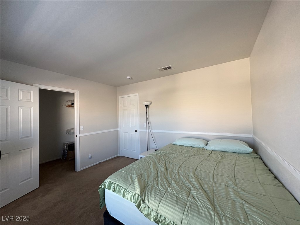 7931 Trea Avenue Las Vegas, NV 89147 - Photo 18 of 25 Bedroom with a walk in closet and dark carpet