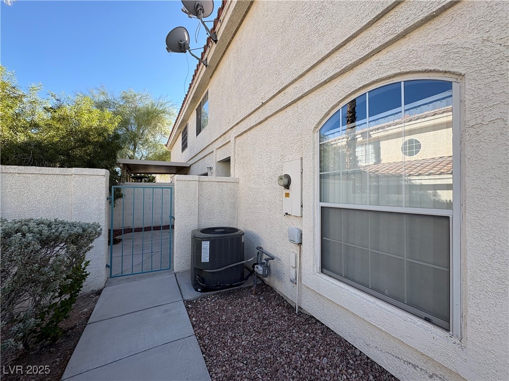 7931 Trea Avenue Las Vegas, NV 89147 - Photo 2 of 25 View of side of home with a gate and stucco siding