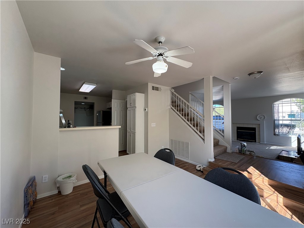 7931 Trea Avenue Las Vegas, NV 89147 - Photo 7 of 25 Dining room featuring stairway, dark wood-style floors, a ceiling fan, and a tiled fireplace