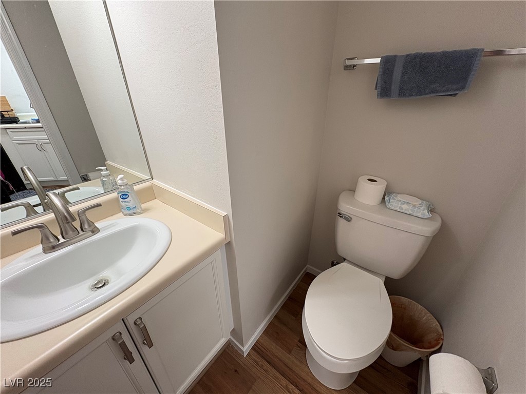 7931 Trea Avenue Las Vegas, NV 89147 - Photo 10 of 25 Half bathroom featuring vanity and dark wood-style floors