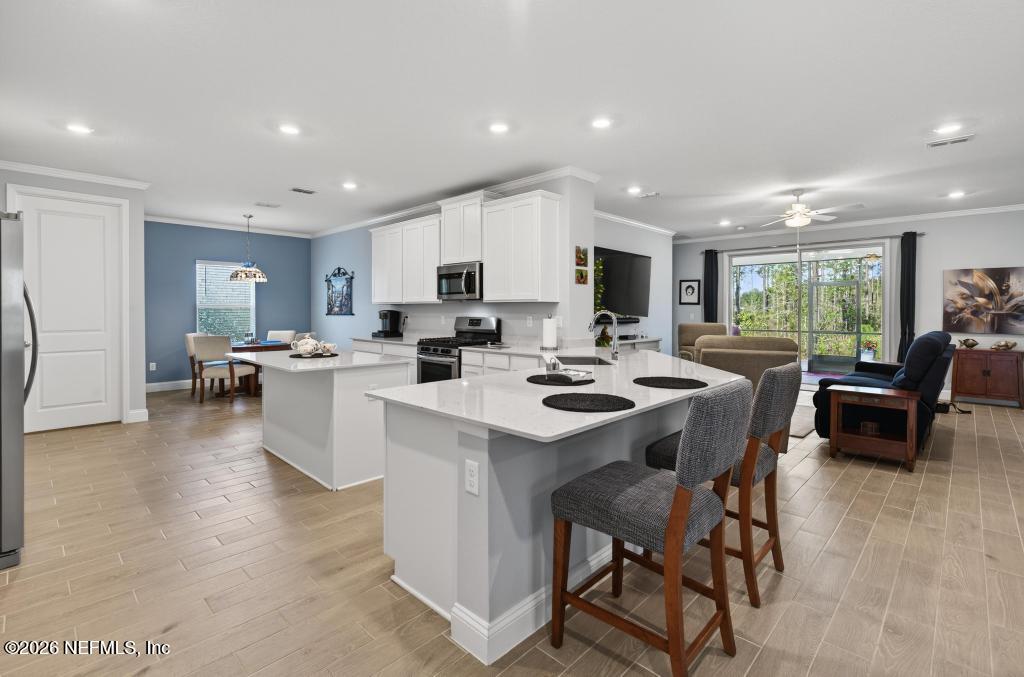 75263 Weathersford Place Yulee, FL 32097 - Photo 13 of 80 a kitchen with a dining table chairs and white appliances