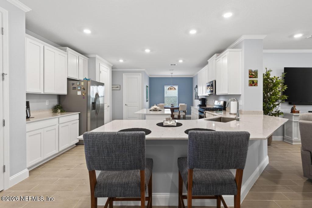 75263 Weathersford Place Yulee, FL 32097 - Photo 14 of 80 a large kitchen with kitchen island a dining table and chairs