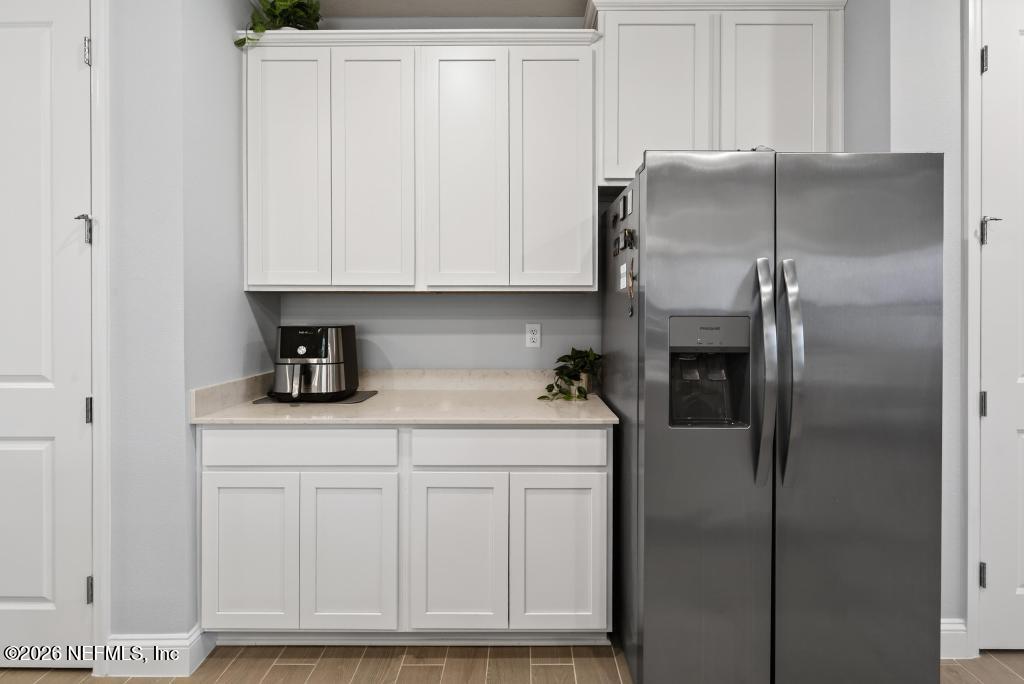 75263 Weathersford Place Yulee, FL 32097 - Photo 16 of 80 a kitchen with white cabinets and stainless steel appliances