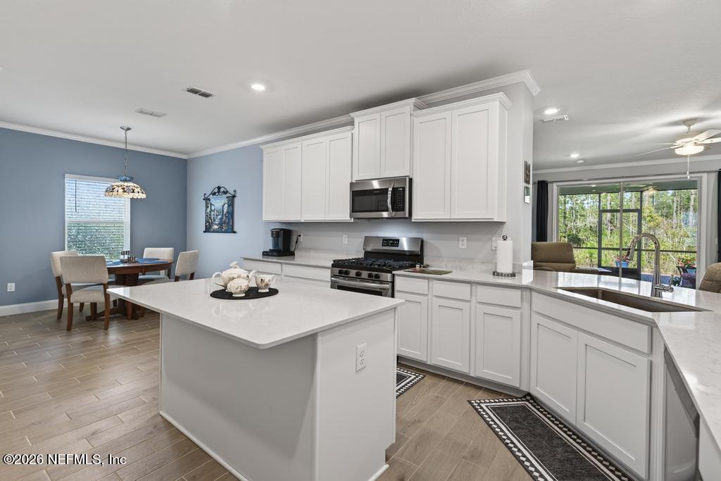 75263 Weathersford Place Yulee, FL 32097 - Photo 18 of 80 a kitchen with a sink a stove a refrigerator and white cabinets