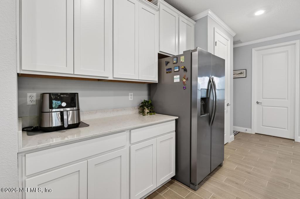 75263 Weathersford Place Yulee, FL 32097 - Photo 22 of 80 a kitchen with stainless steel appliances granite countertop a refrigerator a microwave and cabinets