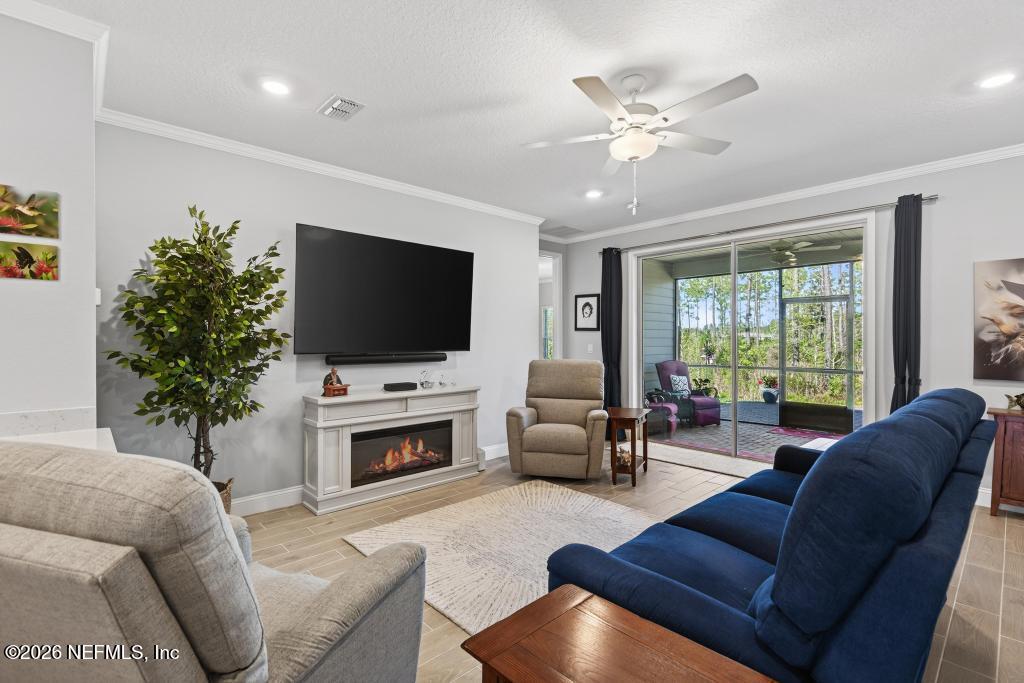 75263 Weathersford Place Yulee, FL 32097 - Photo 34 of 80 a living room with furniture a flat screen tv and a fireplace