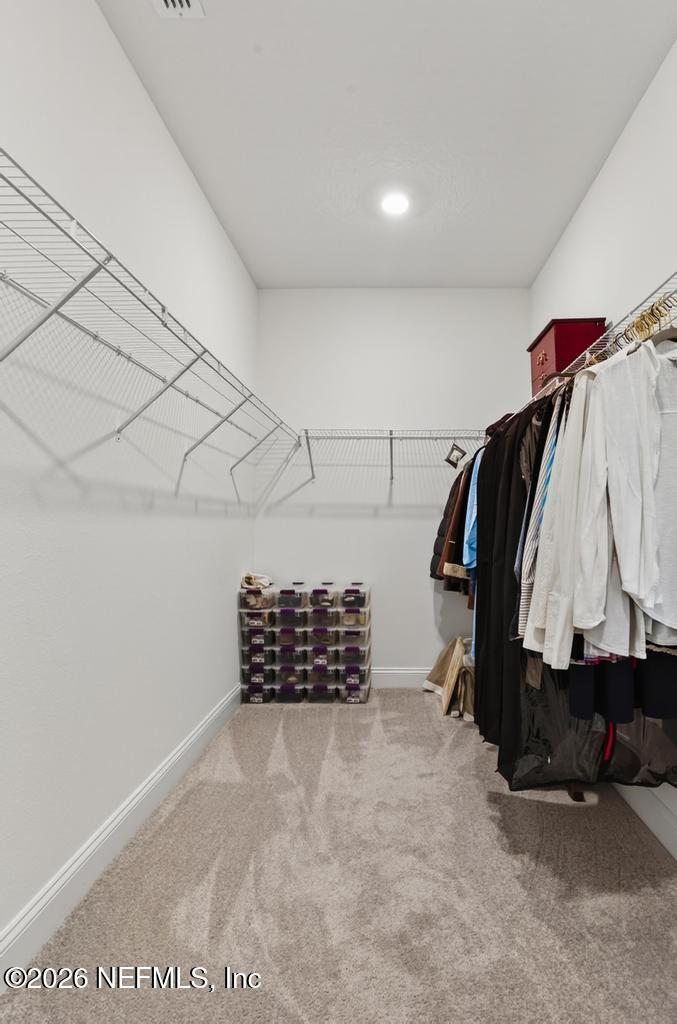 75263 Weathersford Place Yulee, FL 32097 - Photo 47 of 80 a view of walk in closet with clothes