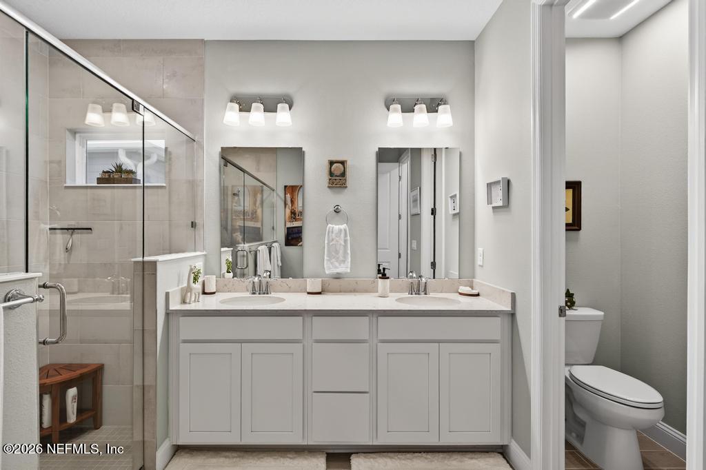 75263 Weathersford Place Yulee, FL 32097 - Photo 49 of 80 a bathroom with a double vanity sink and mirror with toilet