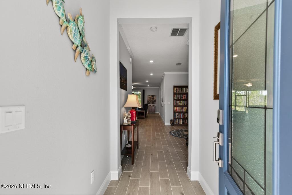 75263 Weathersford Place Yulee, FL 32097 - Photo 10 of 80 a view of a hallway with wooden floor and staircase