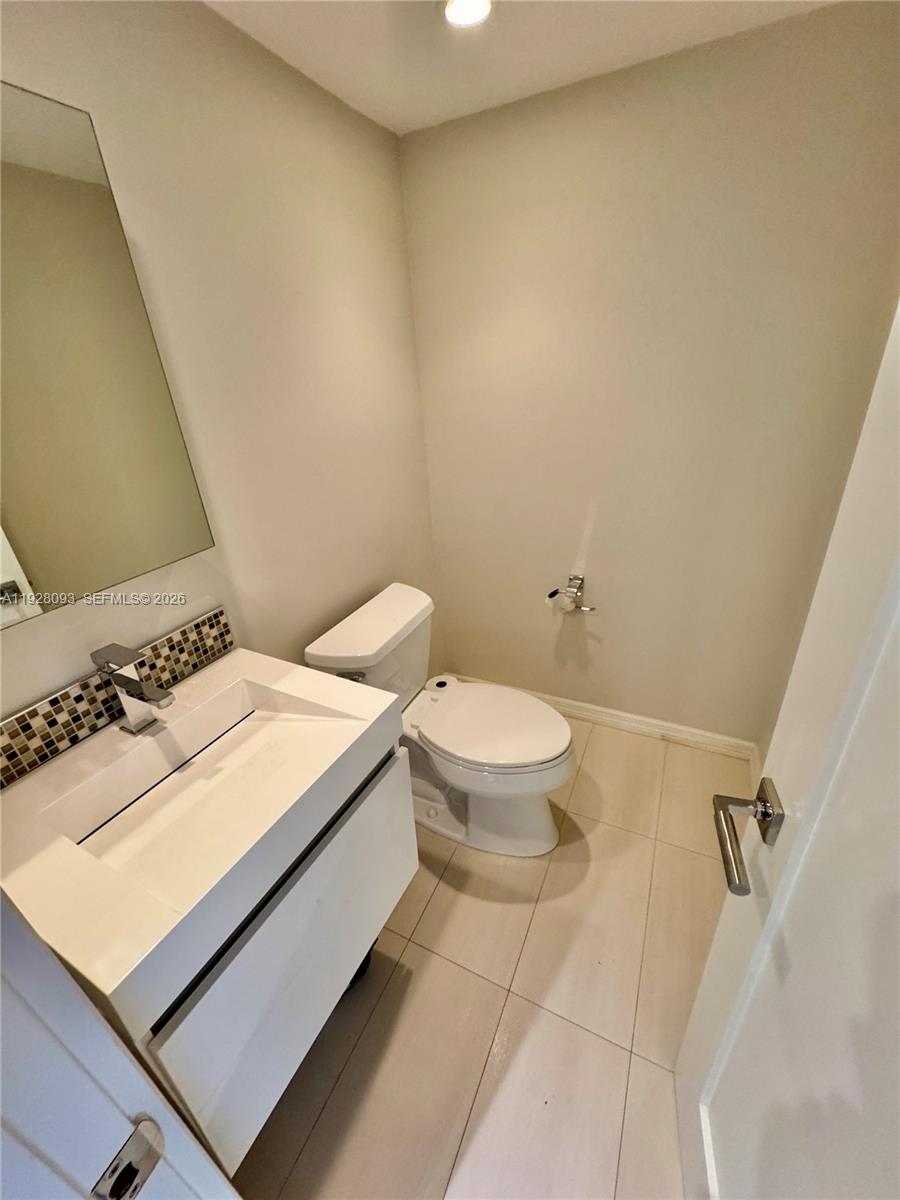 600 Northeast 36th Street, Unit 720 Miami, FL 33137 - Photo 19 of 26 a bathroom with a sink a toilet and a mirror