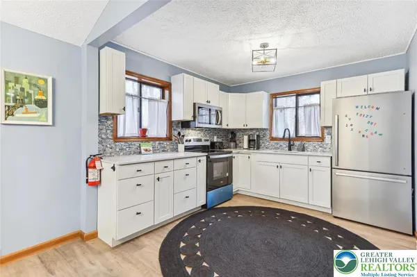 a kitchen with stainless steel appliances a refrigerator sink and cabinets
