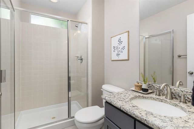 a bathroom with a granite countertop sink toilet and shower