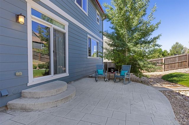 a view of backyard with outdoor seating and a tree