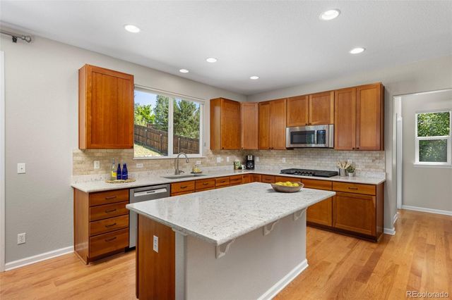 a kitchen with stainless steel appliances granite countertop a sink stove and cabinets