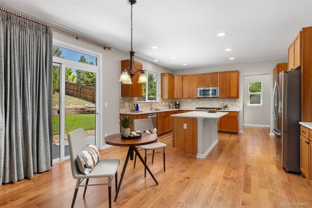 a kitchen with a table chairs refrigerator and microwave