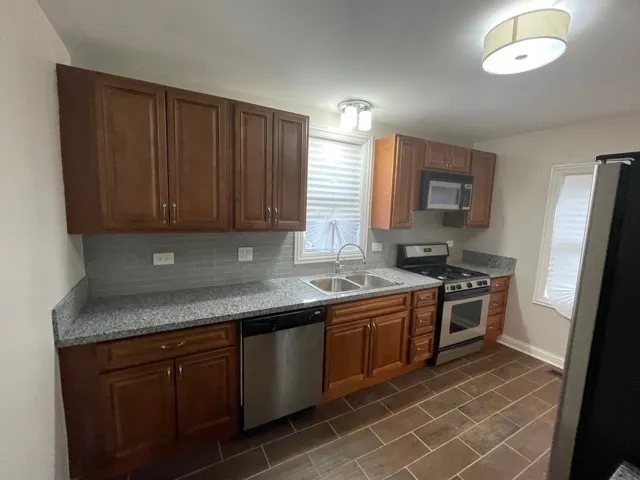 a kitchen with stainless steel appliances granite countertop a stove a sink dishwasher and a refrigerator