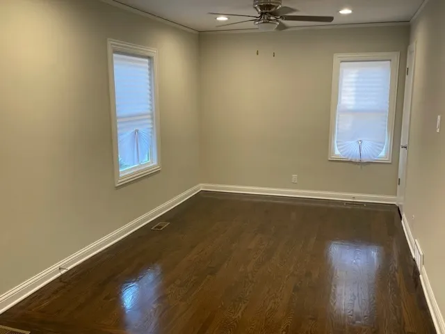 a view of a room with wooden floor and windows