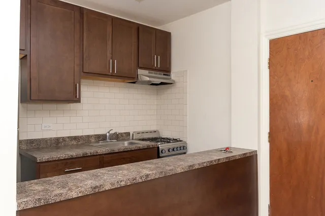 a kitchen with granite countertop a sink and cabinets