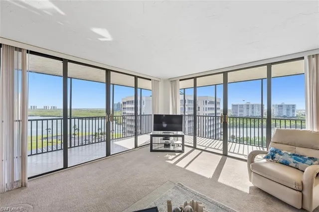a living room with furniture and a floor to ceiling window