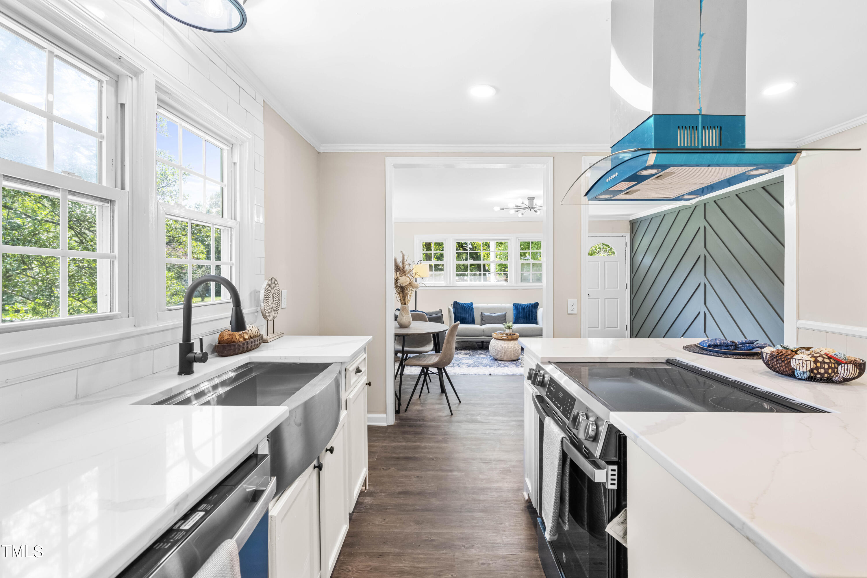 2616 Bullock Road Durham, NC 27704 - Photo 14 of 41 a kitchen with a stove a sink dishwasher and a dining table with wooden floor