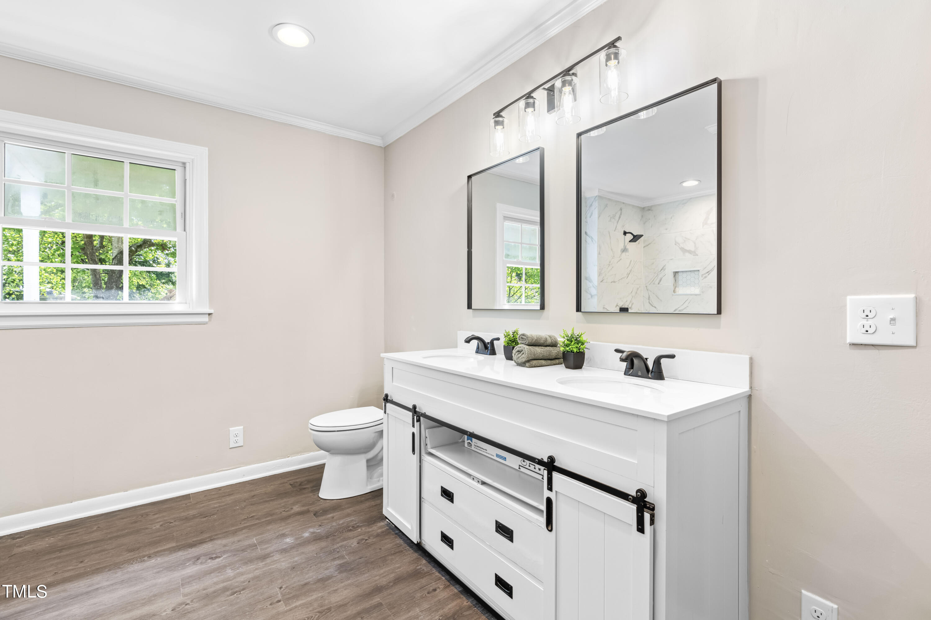 2616 Bullock Road Durham, NC 27704 - Photo 18 of 41 a bathroom with a toilet a sink a mirror and a window