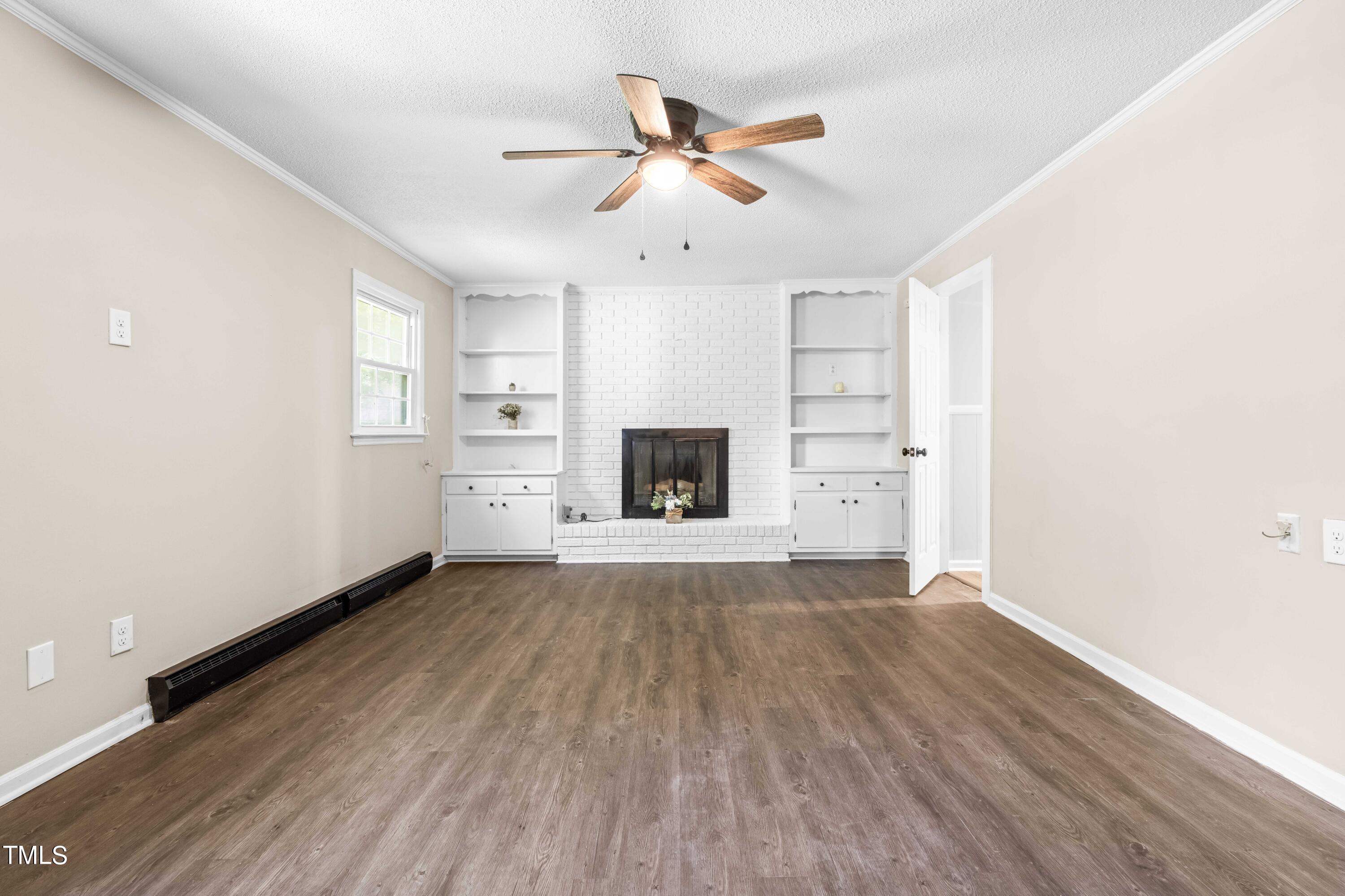2616 Bullock Road Durham, NC 27704 - Photo 25 of 41 an empty room with wooden floor ceiling fan and windows