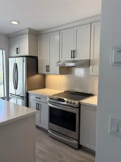 a kitchen with stainless steel appliances granite countertop a stove a refrigerator and a microwave