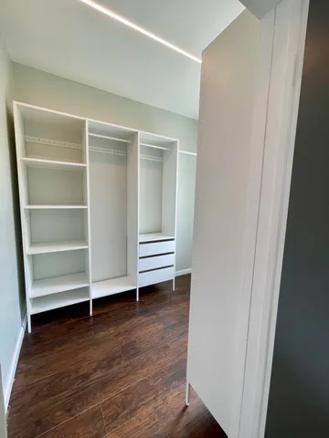 a view of room with wooden floor and white walls