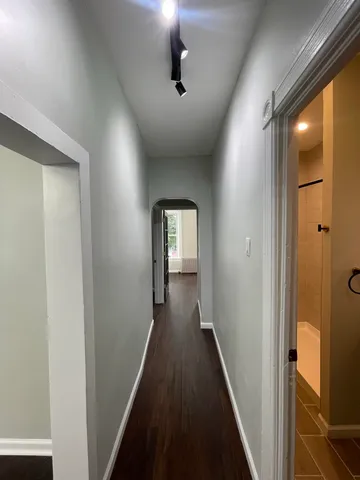 a view of a hallway with wooden floor and staircase