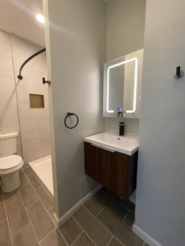 a bathroom with a toilet sink and mirror