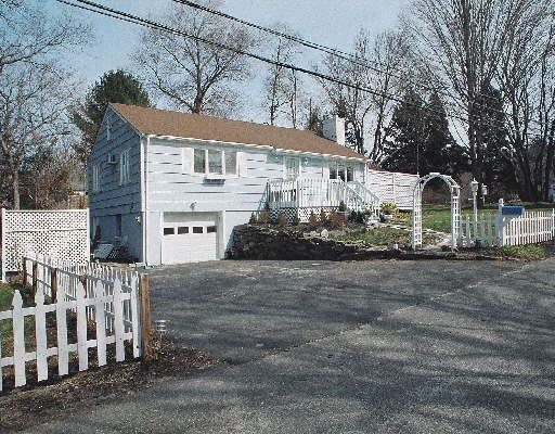 2 Deletta Lane Westport, CT 06880 - Photo 1 of 1 a front view of a house with a road