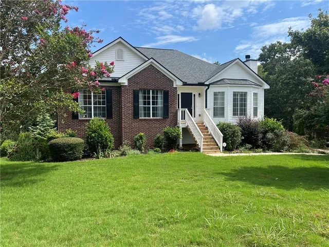 a front view of a house with a yard and trees