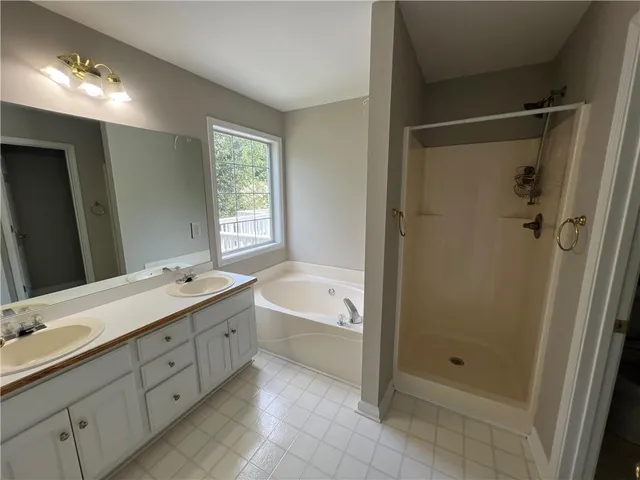 a bathroom with a double vanity sink toilet and shower