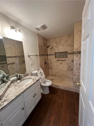 a bathroom with a granite countertop sink toilet and shower